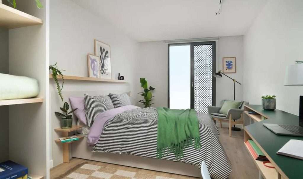 Student Accommodation Maintenance: Tenant Rights in UK 3 The image shows the image of a room with a blanket on the end of the bed and a chair for studies.